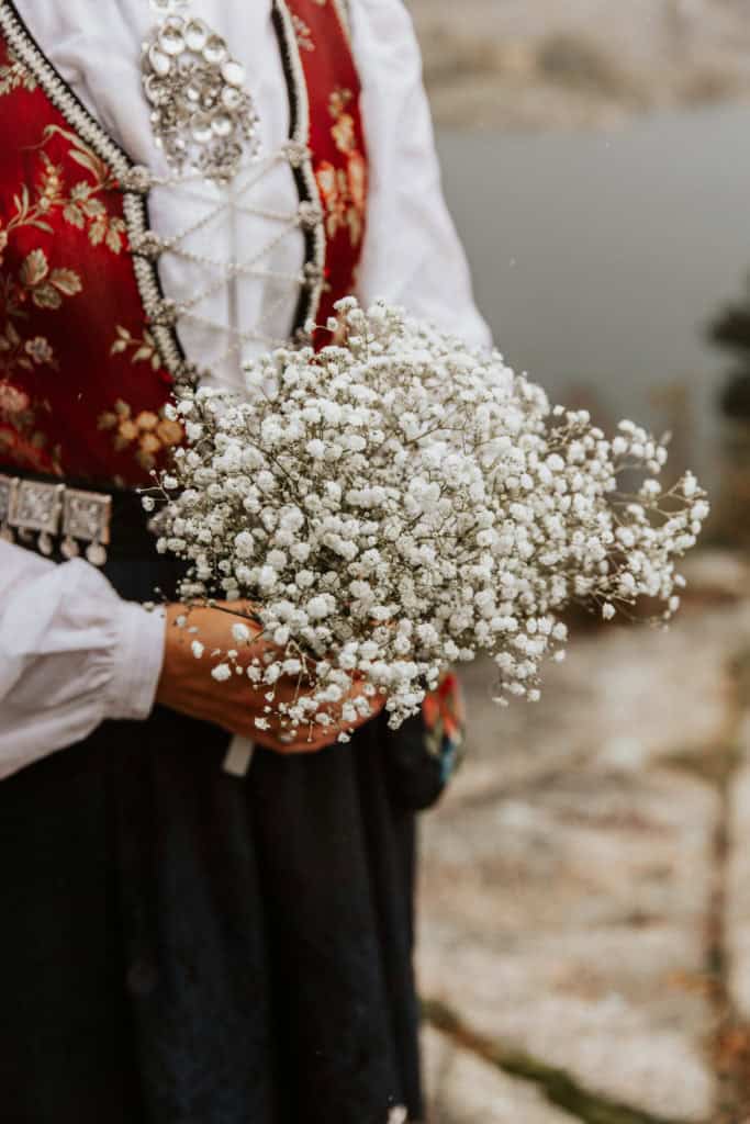 Bryllupsportrett av brud med blomsterbukett ved Lysefjorden, fotografert i naturlig lys.