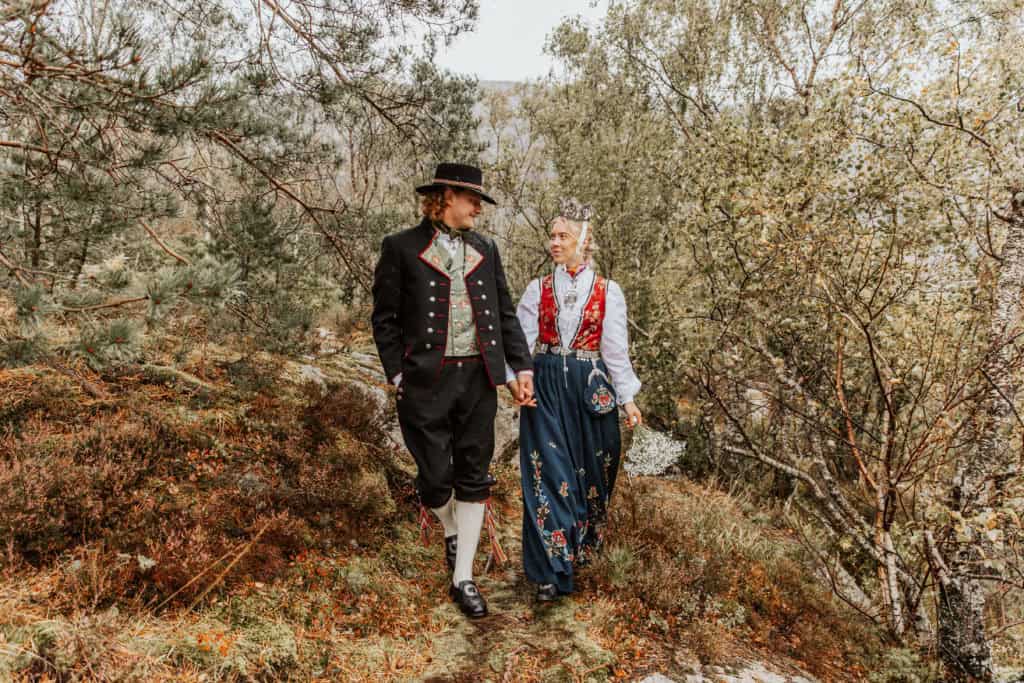 Bryllupsfoto av et par i tradisjonelle klær ved Lysefjorden.