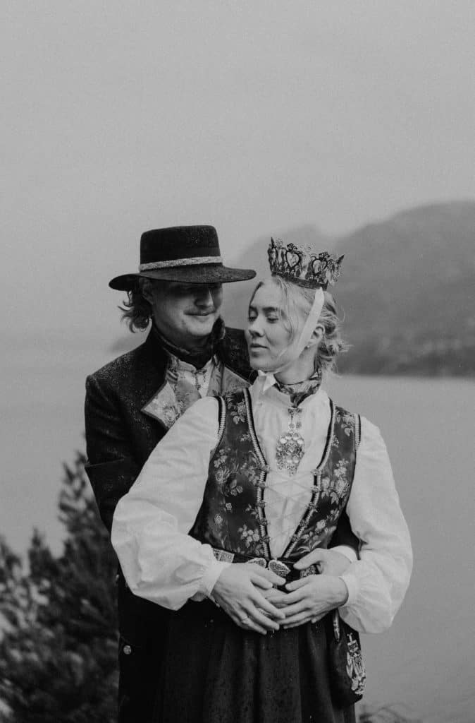 Bryllupsfoto av et par i tradisjonelle klær med Lysefjorden i bakgrunnen.