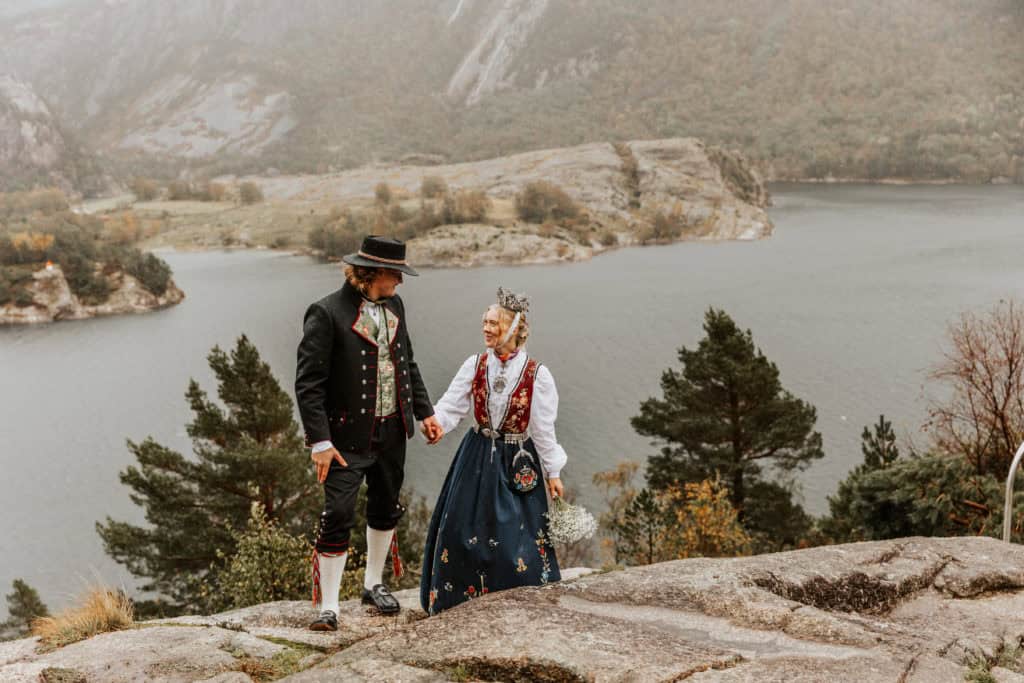 Bryllupsfoto av et par i tradisjonelle klær ved Lysefjorden.